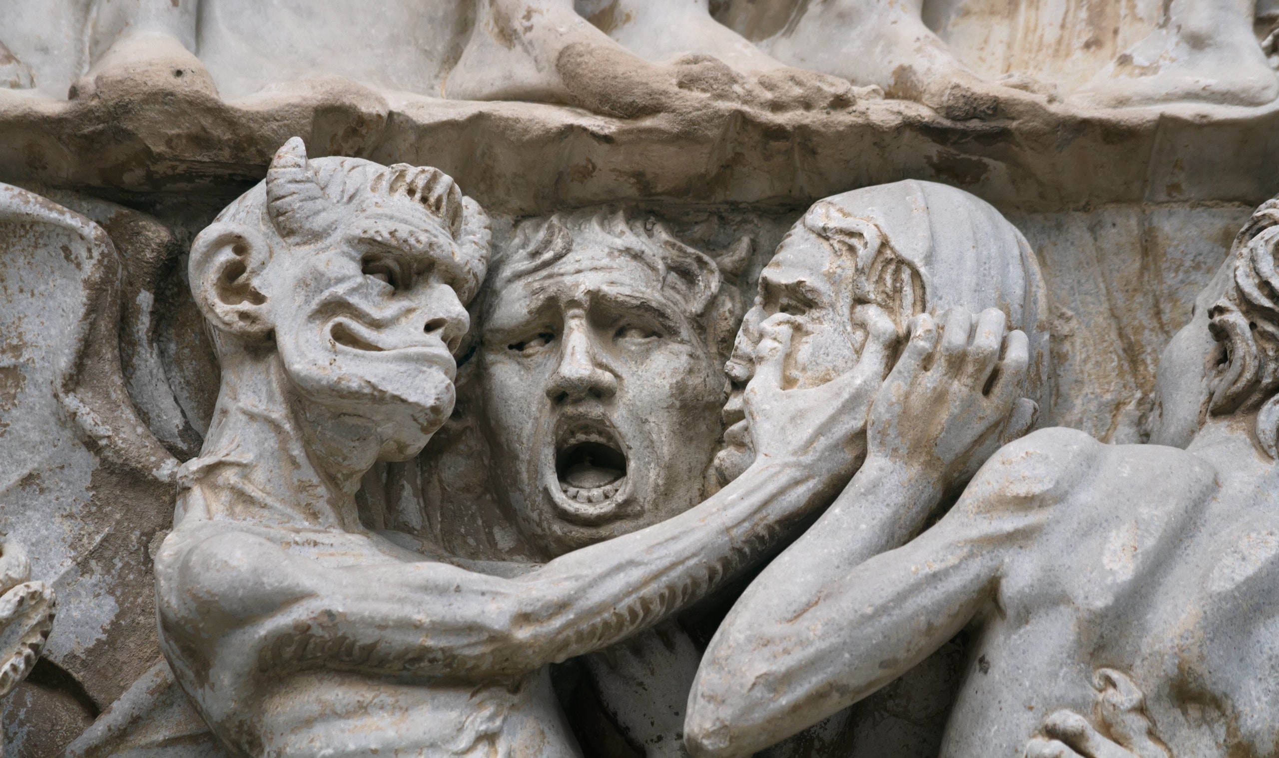 Sculptural group with the image of a devil and sinners on an external facade of the Cathedral, Orvieto, Italy