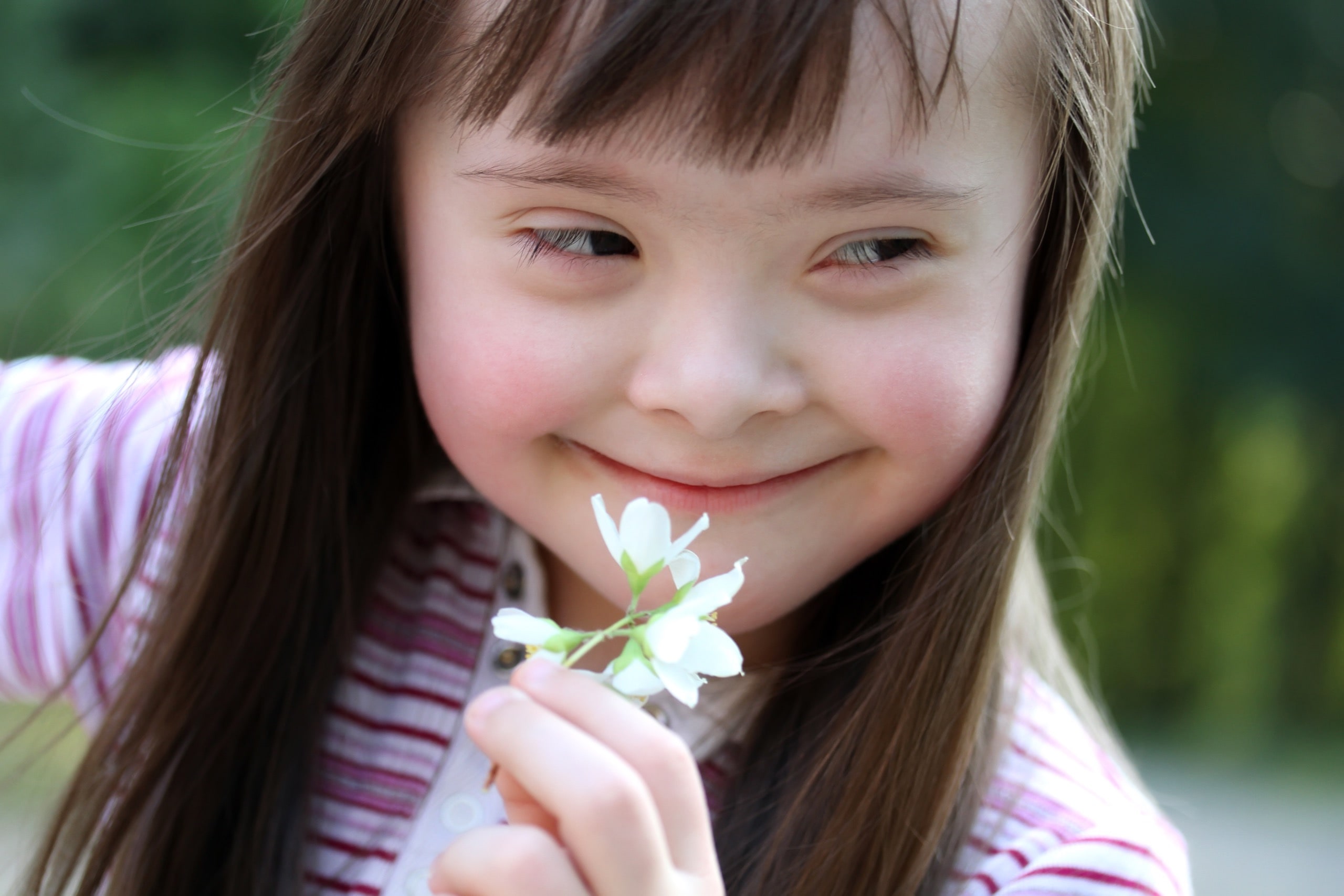 Portrait of beautiful young girl with flowers in the park